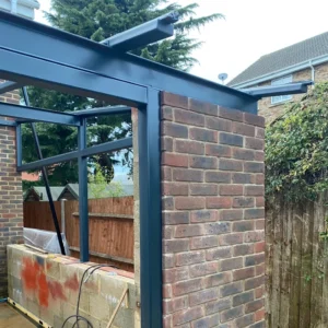 Anthracite grey fast-drying semi-gloss paint on an exterior steel post and beam beside a brick house, showing a smooth, even finish.