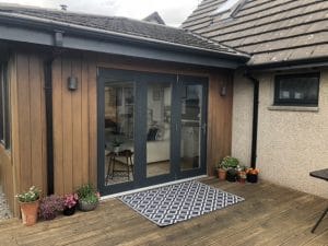 exterior of customer's house with patio door painted anthracite (dark) grey satin finish paint with plants and decking 