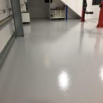 Shiny, pale grey painted concrete floor in warehouse