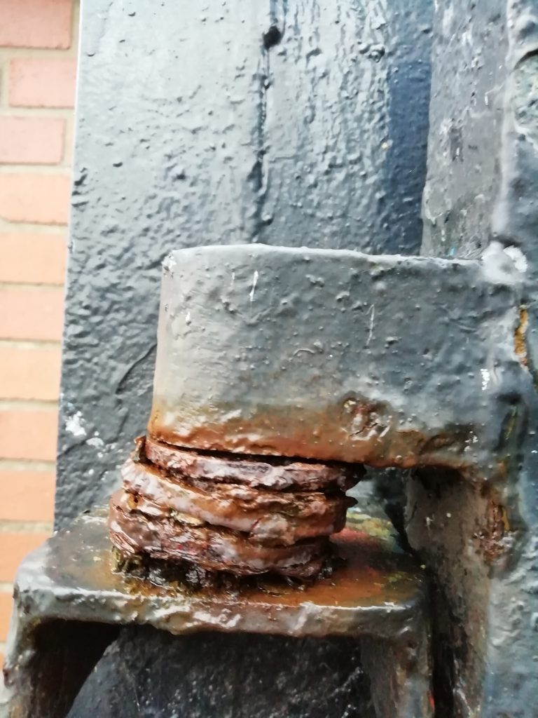 Close up of rust on a heavy duty gate hinge