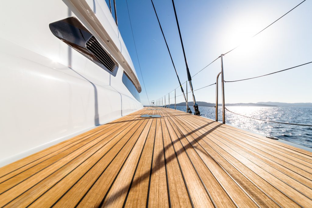 Deck of a yacht on a glittery calm sea, deck is newly treted with yacht varnish