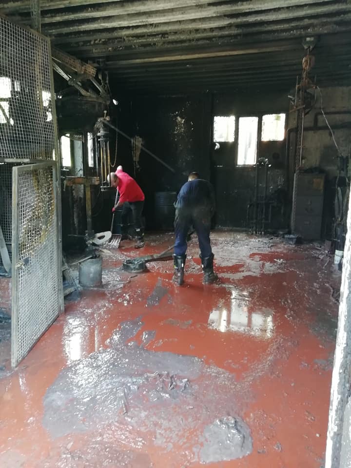 Workmen cleaning up in burnt out factory room