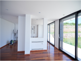 White painted room with wooden floor and large sliding glass doors to outside
